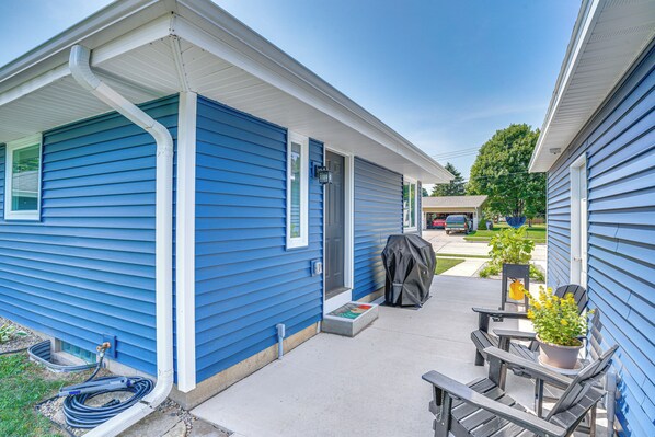 A blue single-story house with a covered patio area, a barbecue grill, and a garden chair. - 2 Mi to Lake Michigan: Family-friendly Home (Manitowoc)