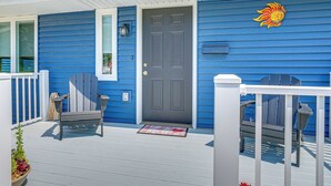 A blue house with a gray door, a bench, and a chair on the porch. - 2 Mi to Lake Michigan: Family-friendly Home (Manitowoc)