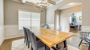 A dining area with a wooden table, gray chairs, and a chandelier. - Patio w/ Fireplace: Spacious Sharpsburg Home! (Sharpsburg)