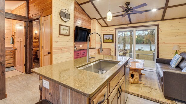 A wooden cabin interior with a kitchen, dining area, and a cozy living room. - Minong Flowage Cabin w/ Fire Pit & Dock! (Gordon)