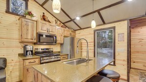 A kitchen with wooden cabinets, a stainless steel sink, and a granite countertop. - Minong Flowage Cabin w/ Fire Pit & Dock! (Gordon)