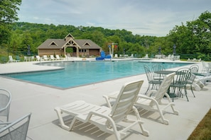 A pool area with lounge chairs and a building in the background. - Spacious Modern Home ~ 1 Mi to Camelback Mountain! (Tannersville)