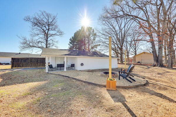 A house with a covered patio, a fire pit, and a wooden deck.