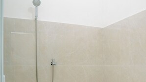 A bathroom with a shower, toilet, and tiled floor. -  Villa CHR Syariah (Banjarbaru)