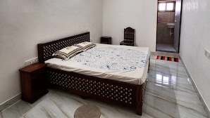 Une chambre à coucher comprenant un lit, une table de chevet, un ventilateur de plafond et un appareil de climatisation.