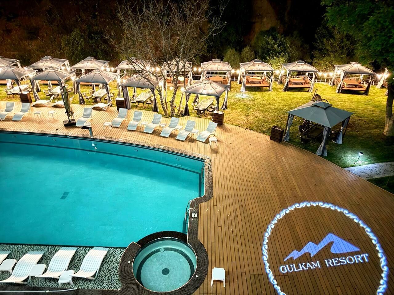 A poolside area with lounge chairs and umbrellas at Gulkam Resort.