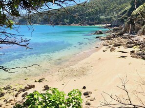 A beach with clear turquoise water, sandy shore, and rocky outcrops. - The Cliffs - AT Seiramar Area (Viveiro)