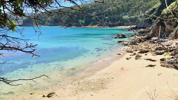 A beach with clear turquoise water, sandy shore, and rocky outcrops. - The Cliffs - AT Seiramar Portonovo (Viveiro)
