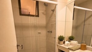 A modern bathroom with a toilet, shower, and sink area. - Reserva do Sahy, Condado (Mangaratiba)