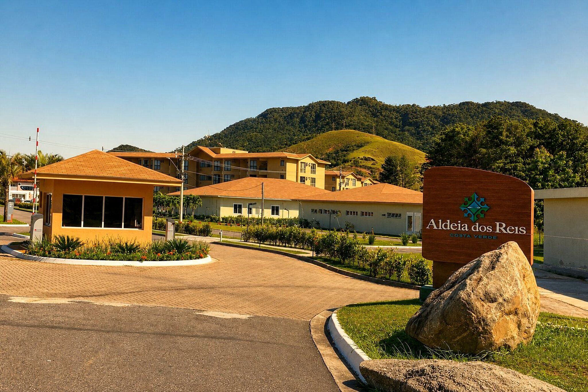 Entrada de hotel com uma placa indicando 'Aldea dos Reis Costa Verde'.