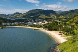 A coastal area with a beach, a marina, and a residential area with buildings. - Reserva do Sahy, Condado (Mangaratiba)