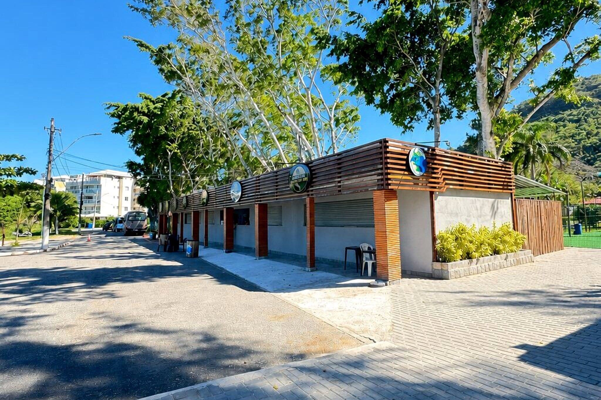 A modern building with a flat roof, multiple windows, and a paved entrance area.