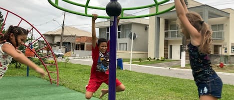 Crianças brincando em equipamentos de parque infantil.