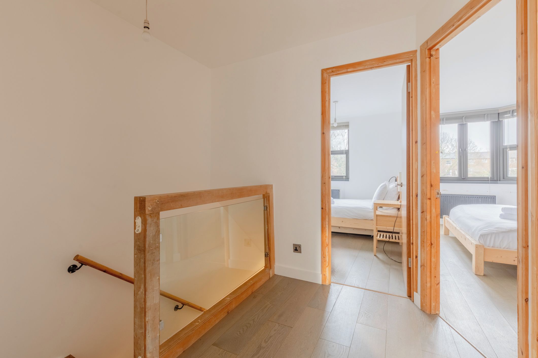 A room with a wooden-framed window, a bed, a chair, and a small table.