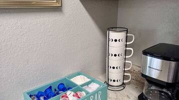 Eine Küchenarbeitsplatte mit einer Kaffeebar, einer Kaffeemaschine und einem Schild mit der Aufschrift 'LESS IS MORE UNLESS IT'S COFFEE'.