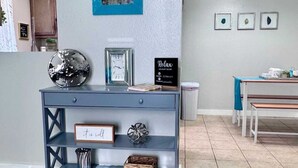 A modern living room with a blue console table, a mirror, and a chandelier. - Comfy 2BR 1BA Apt (Nederland)