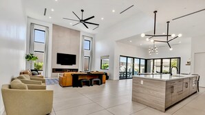 A spacious living area with a large island, modern furniture, and a flat-screen TV. - Luxury Lounge - 5BR, Pool&Spa, Sauna, Firepit (Scottsdale)