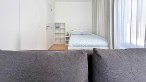 Un dormitorio con cama, armario y escritorio.