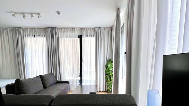 Una sala moderna con un sofá, una mesa de centro y un televisor.