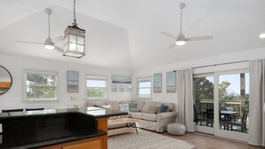 A spacious living area with a large window, a ceiling fan, and a dining area with a table and chairs. - Pool, Phenomenal Sunsets Await, Dogs Welcome, Spacious, D0101 (Duck)