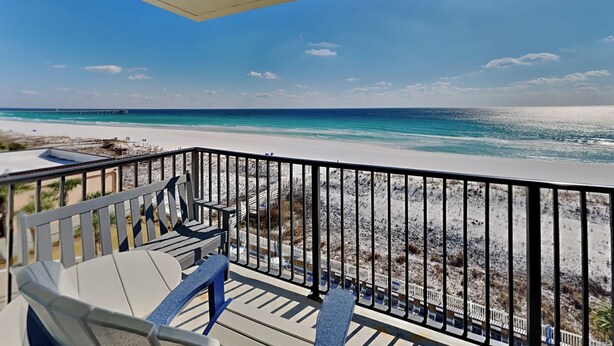 A balcony with a view of a beach and ocean.