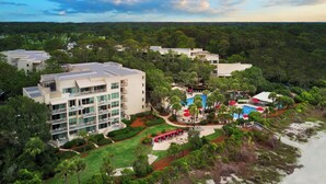 A resort with multiple buildings, a pool area, and lush greenery.