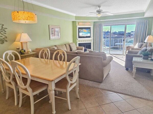 A living room with a dining table, sofas, and a TV.