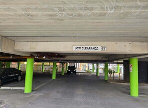 An underground parking area with green pillars and a low clearance sign indicating 6'8".
