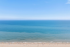 A beach with clear blue water and a sandy shore. - Midtown , 3 bedroom, 3 bathroom, 2 level condo, close to the beach (Ocean City)