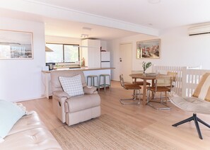Relax in a welcoming space with a sofa, chair, and dining table, surrounded by natural views.