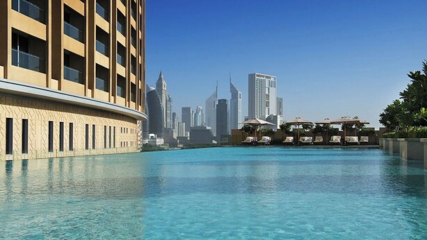 A swimming pool with a city skyline in the background. - Burj View Studio Downtown (Dubai)