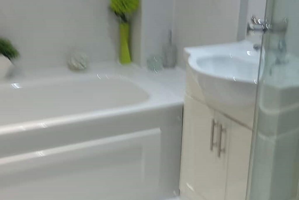 A bathroom with a white bathtub, a sink, and a cabinet.