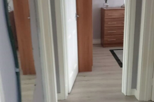 Un pasillo con puertas de madera y un aparador con cajones.