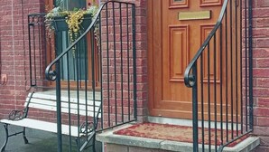 A brick building with a wooden door and a bench outside. - Sea Surf, 2 bedroom, fully equipped ground floor apartment, sleeps 4, in city (Bangor)