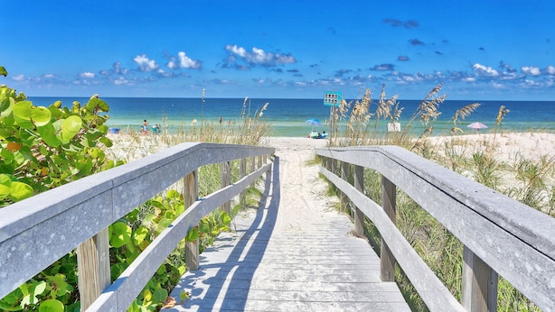 A wooden boardwalk leading to a beach with clear blue water and a sandy shore. - 🏖️Beachfront🌴Heated Pool, Hot Tub-Direct Beach Access-Land's End 10-303🌊 (Treasure Island)