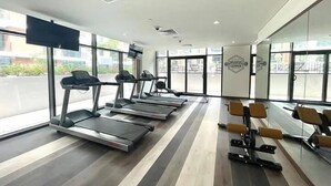 A gym with treadmills, weight machines, and large windows.