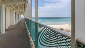 A corridor with a view of a beach and ocean.