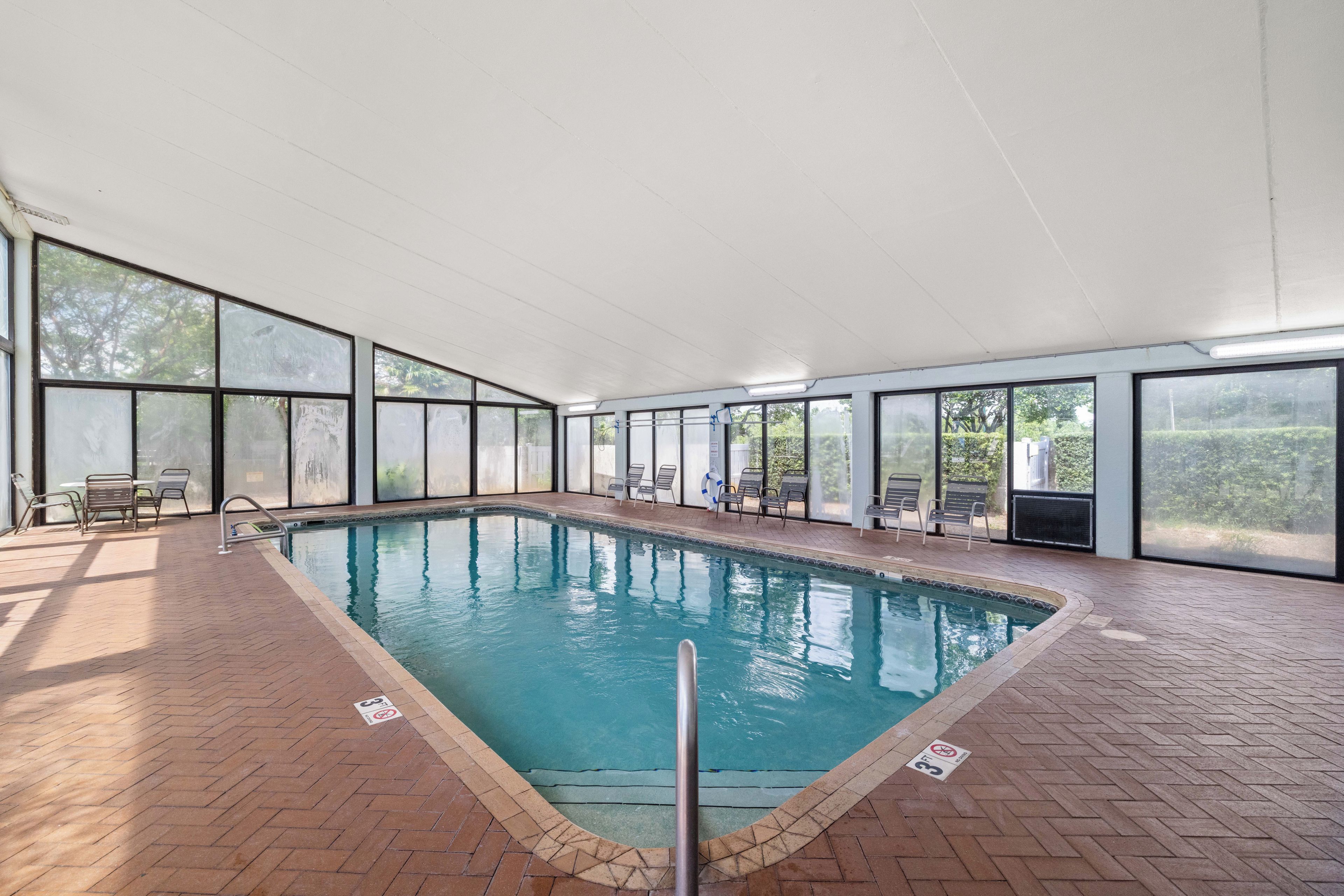 Una piscina interna con pavimento piastrellato, scaletta e galleggiante.