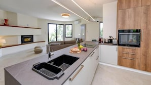 Eine moderne Küche mit Kochinsel, Backofen und Holzausstattung.