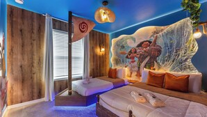 Une pièce avec un lit, une fenêtre avec des stores, une fresque murale et un luminaire suspendu.