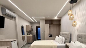 Habitación de hotel con dos camas, un escritorio, un espejo, un armario y un baño.