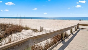A beach with a wooden boardwalk leading to the water. - Phoenix V Beachfront Family Condo with Pool and Gulf Views (Orange Beach)