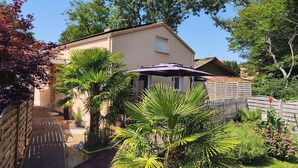 A house with a garden, a wooden fence, and a patio umbrella. - Gîte 2 **, 55m², 2/4 persons, quiet, 20 min from the beaches Pornic, st Brévin (Vue)