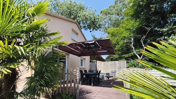 A wooden deck with outdoor furniture, a pergola, and surrounding greenery. - Gîte 2 **, 55m², 2/4 persons, quiet, 20 min from the beaches Pornic, st Brévin (Vue)