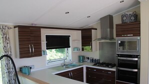 Una cocina compacta con fregadero, estufa y microondas.