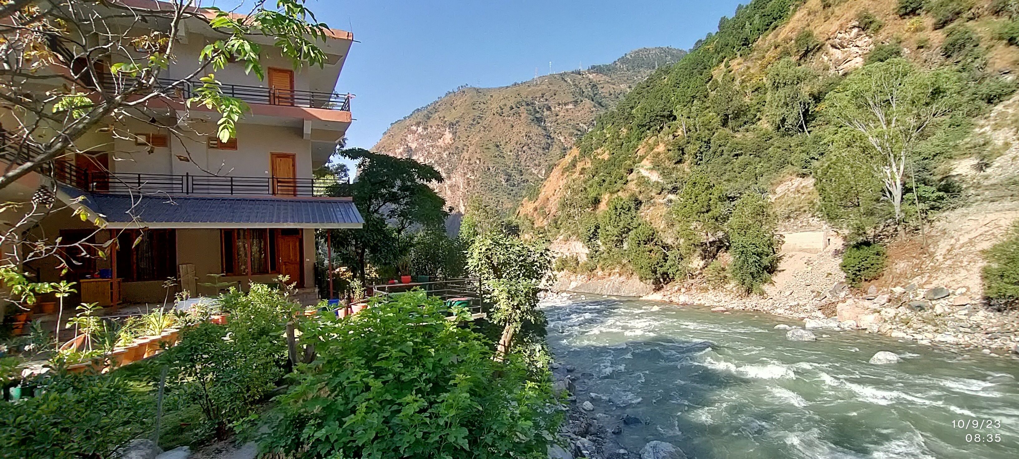 A multi-story building with balconies overlooking a river.