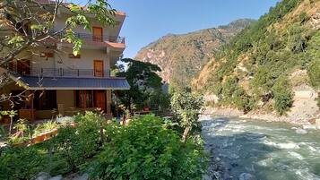 A multi-story building with balconies overlooking a river.