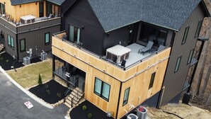 A modern two-story house with a balcony, large windows, and a flat roof.