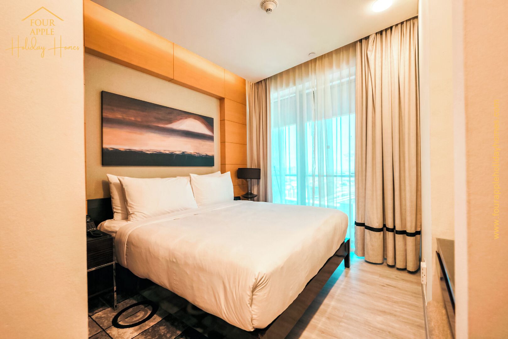 A hotel room with a large bed, a painting on the wall, a bedside table, and a window with curtains.