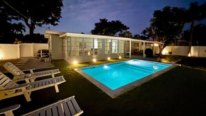 A modern house with a swimming pool, a covered patio, and lounge chairs. - Beautiful 3 2 Home in Pompano Beach - Close to Beach (Pompano Beach)